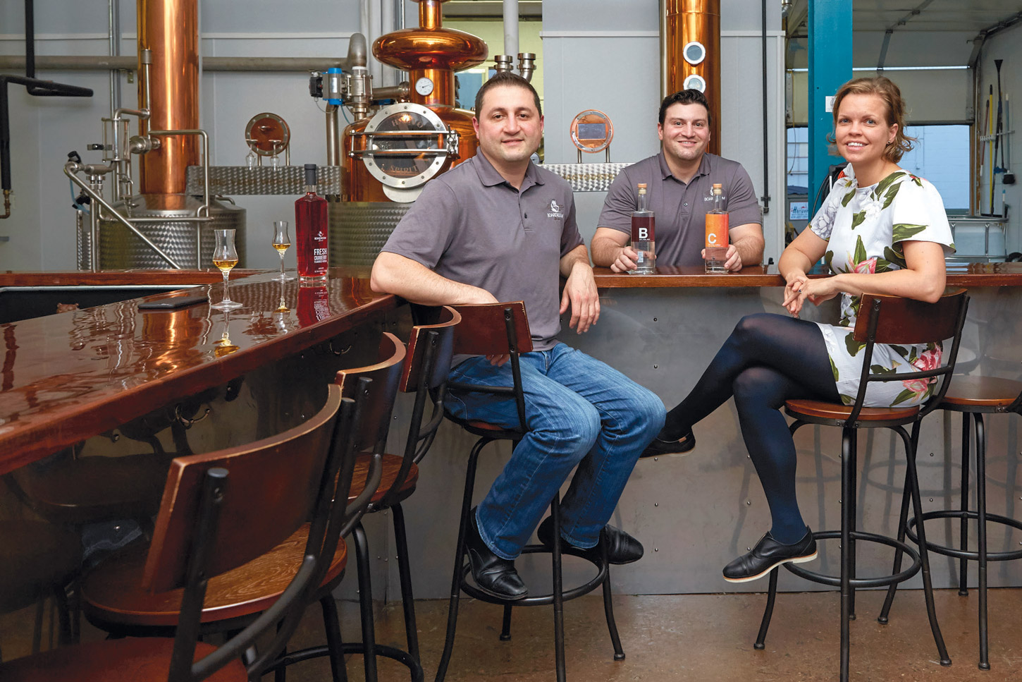 Owners of Boardroom Spirits, Vlad Mamedov, Marat Mamedov, and Zsuzsa Palotas enjoying cocktails in the distillery’s tasting room