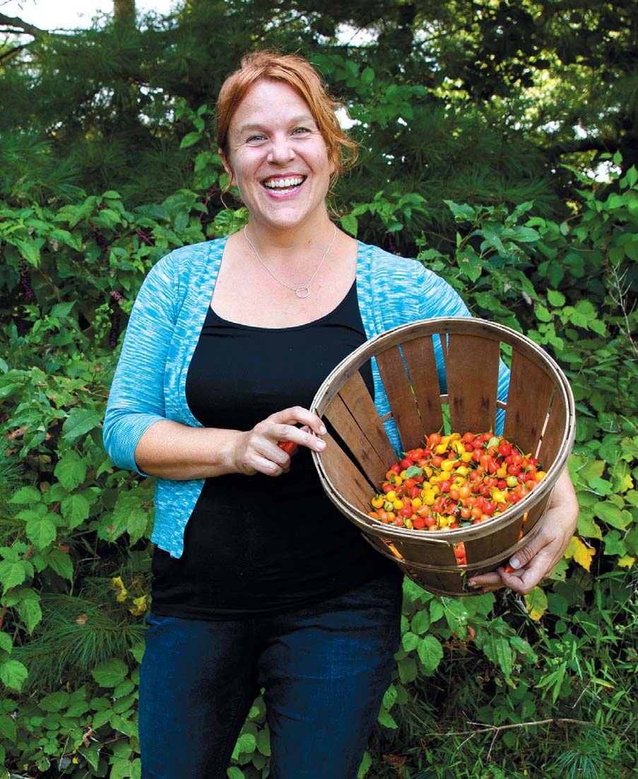 Robyn Jasko holding basket of Pimenta Biquino peppers.