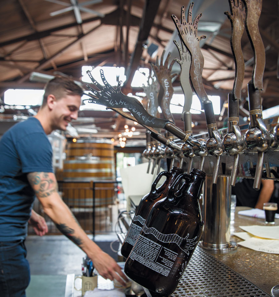 A bartender fills growlers at the Tired Hands Fermentaria in Ardmore.