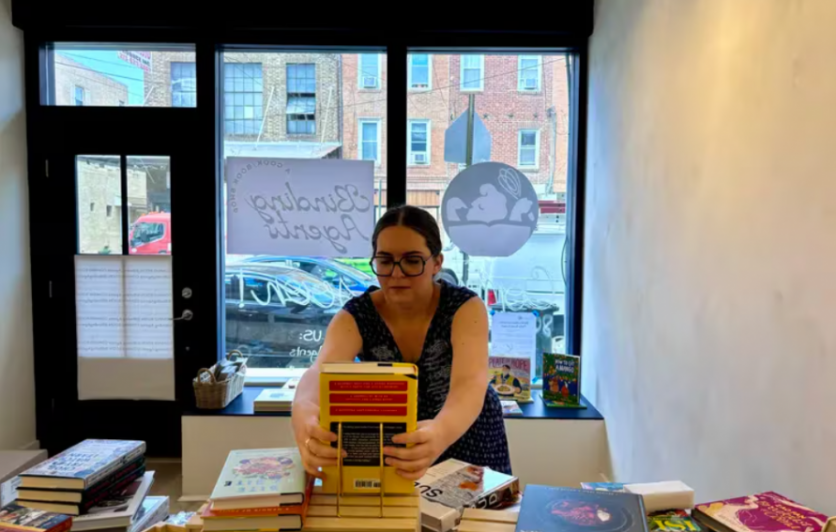 Interior of Binding Agents: A Cook/Book Shop with owner, Catie Gainor, arranging books for display.