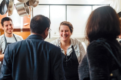 Sydney Hanick and Ryan Fitzgerald talk with guests in the kitchen at Boku